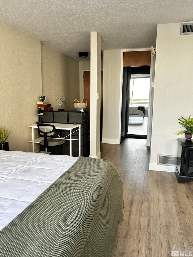 100 N Arlington Ave Unit 8C, Reno, NV 89501 - bedroom featuring wood finished floors, a textured ceiling, a textured wall, and baseboards