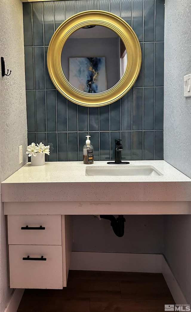 100 N Arlington Ave Unit 8C, Reno, NV 89501 - bathroom featuring a textured wall, backsplash, and a sink