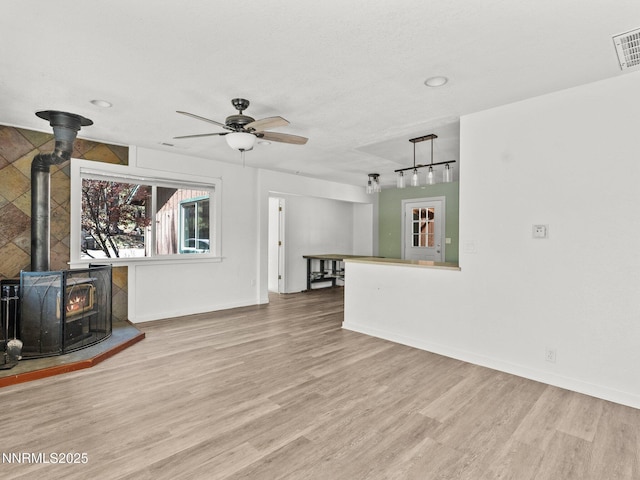1713 Tionontati St, South Lake Tahoe, CA 96150 - unfurnished living room featuring a wood stove, wood finished floors, ceiling fan, baseboards, and recessed lighting