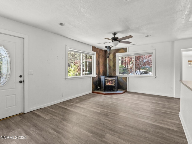 1713 Tionontati St, South Lake Tahoe, CA 96150 - foyer featuring a wood stove, a textured ceiling, wood finished floors, baseboards, and ceiling fan