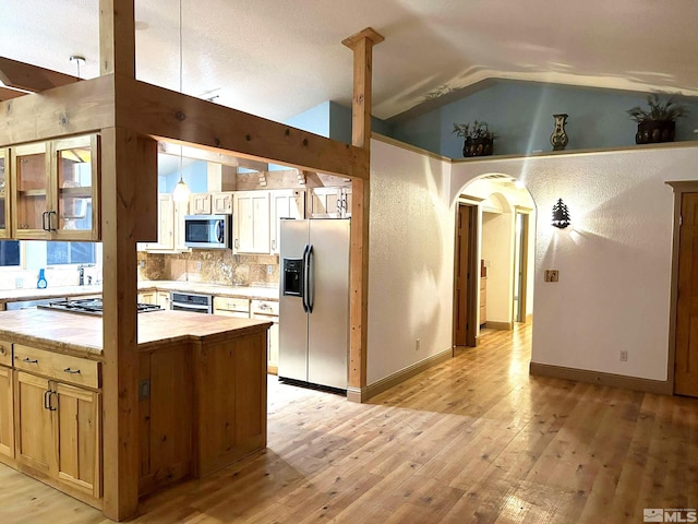 21410 Sazarac Rd, Reno, NV 89521 - kitchen with stainless steel appliances, lofted ceiling, light wood-style flooring, light countertops, and arched walkways
