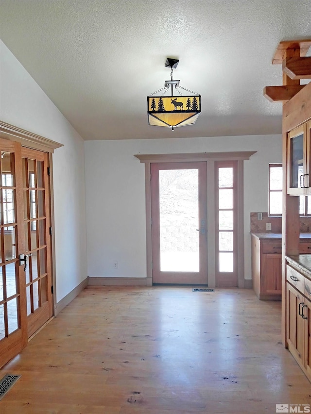 21410 Sazarac Rd, Reno, NV 89521 - unfurnished dining area featuring light wood finished floors, a textured ceiling, french doors, and baseboards