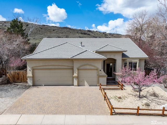 159 River Flow Dr, Reno, NV 89523 - view of front of property with fence, an attached garage, driveway, stucco siding, and a tile roof