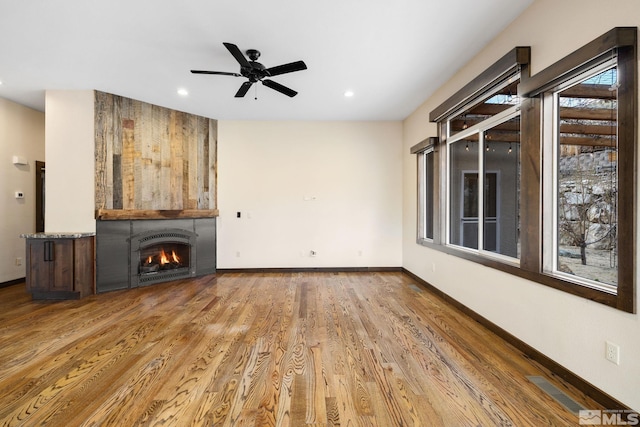 159 River Flow Dr, Reno, NV 89523 - unfurnished living room featuring a fireplace, ceiling fan, wood finished floors, baseboards, and recessed lighting