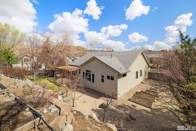 159 River Flow Dr, Reno, NV 89523 - view of property exterior with stucco siding, a patio, a tiled roof, and fence