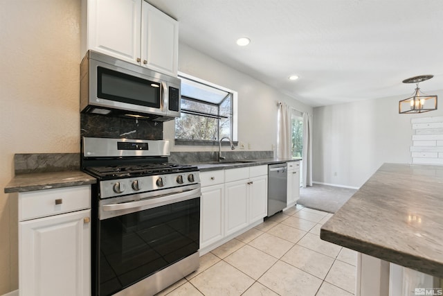 1599 Lucerne, Minden, NV 89423 - kitchen with stainless steel appliances, a sink, white cabinetry, decorative backsplash, and light tile patterned floors