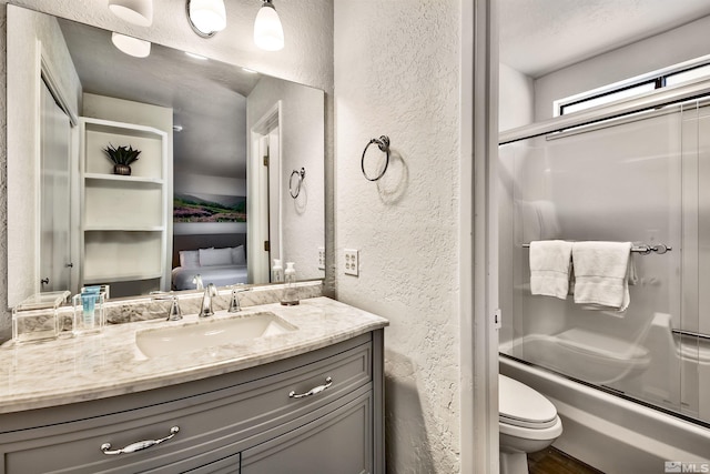 245 Tramway Dr, Stateline, NV 89449 - bathroom with a textured wall, vanity, toilet, enclosed tub / shower combo, and wood finished floors