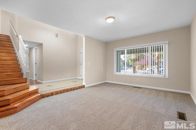 4550 Noche Ln, Reno, NV 89502 - unfurnished living room with baseboards, carpet flooring, and stairs