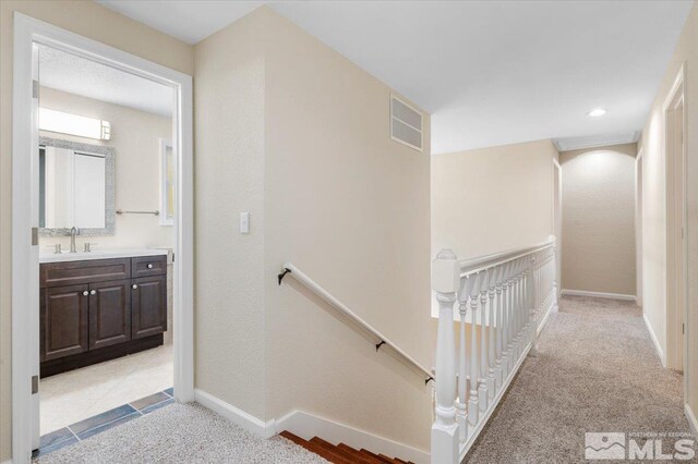 4550 Noche Ln, Reno, NV 89502 - corridor featuring an upstairs landing, a sink, light colored carpet, and baseboards