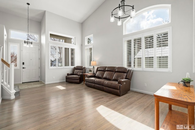 5895 Tappan Dr, Reno, NV 89523 - living room with a chandelier, a towering ceiling, stairway, baseboards, and healthy amount of natural light