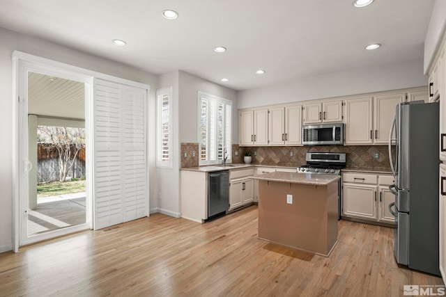 5895 Tappan Dr, Reno, NV 89523 - kitchen with appliances with stainless steel finishes, a center island, backsplash, light wood-type flooring, and recessed lighting