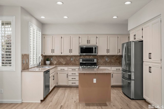 5895 Tappan Dr, Reno, NV 89523 - kitchen featuring appliances with stainless steel finishes, a sink, light wood-style floors, light stone countertops, and backsplash