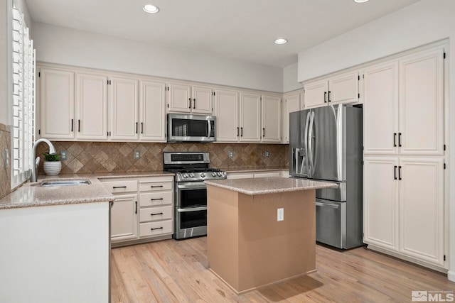 5895 Tappan Dr, Reno, NV 89523 - kitchen with stainless steel appliances, a sink, light wood-style flooring, recessed lighting, and decorative backsplash