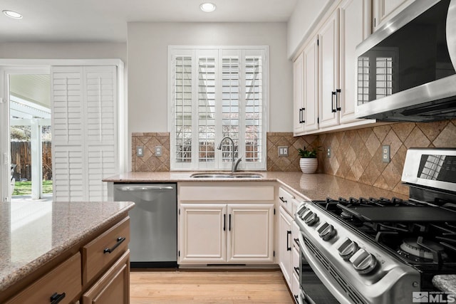 5895 Tappan Dr, Reno, NV 89523 - kitchen with appliances with stainless steel finishes, ventilation hood, a sink, light stone counters, and recessed lighting