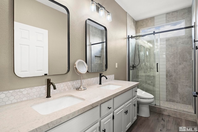5895 Tappan Dr, Reno, NV 89523 - full bathroom featuring wood finished floors, a shower stall, toilet, double vanity, and a textured wall