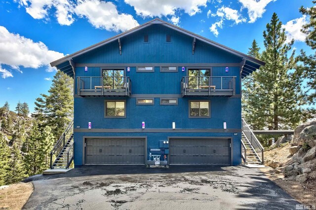 243 Tramway Dr, Stateline, NV 89449 - view of front facade featuring a balcony, stairway, a garage, and driveway