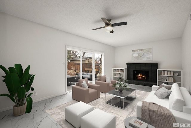living area with marble finish flooring, a ceiling fan, a fireplace, a textured ceiling, and baseboards