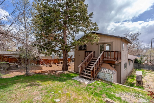 rear view of property with fence, a deck, and stairs