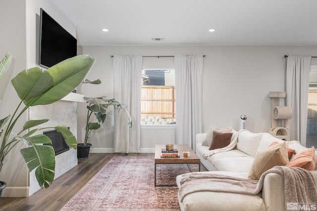 living room featuring wood finished floors, baseboards, and recessed lighting
