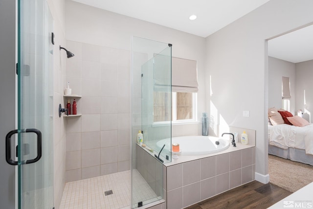 bathroom with ensuite bathroom, a stall shower, wood finished floors, and a bath