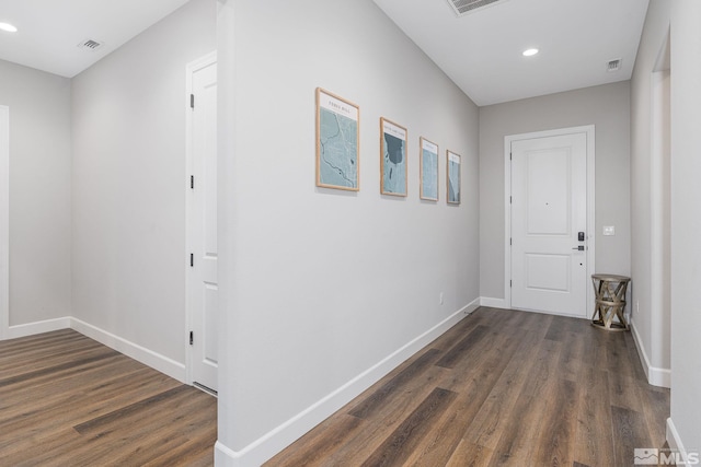 corridor with dark wood-type flooring, baseboards, and recessed lighting