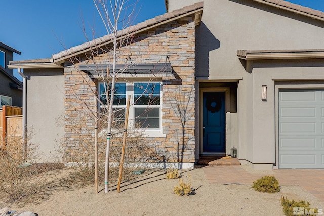 view of exterior entry featuring stone siding and stucco siding