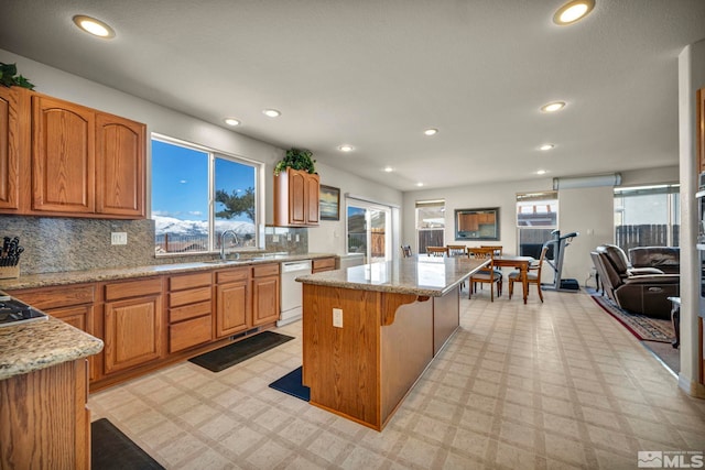 2861 Sunline Dr, Reno, NV 89523 - kitchen with a center island, dishwasher, a sink, light stone counters, and recessed lighting