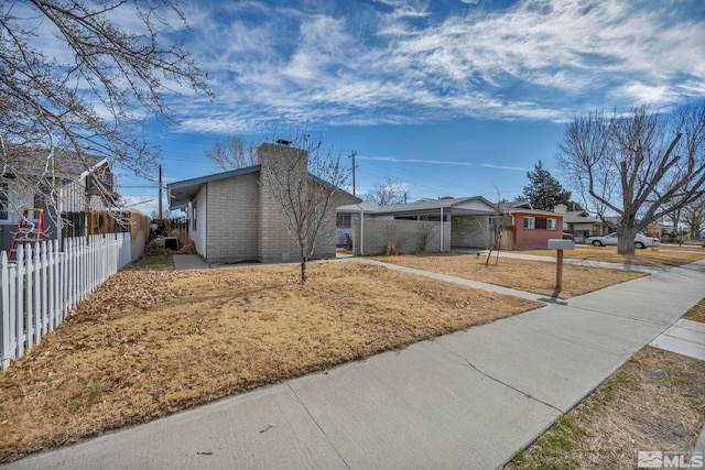 435 Cindy, Fallon, NV 89406 - view of front facade featuring a chimney, fence, brick siding, driveway, and a carport