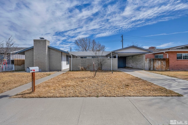 435 Cindy, Fallon, NV 89406 - view of front of property featuring brick siding, fence, driveway, a chimney, and a carport