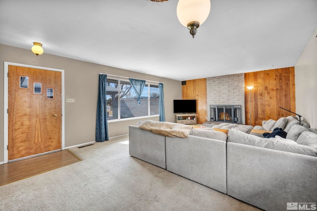 435 Cindy, Fallon, NV 89406 - living room featuring wooden walls, a fireplace, carpet floors, and baseboards