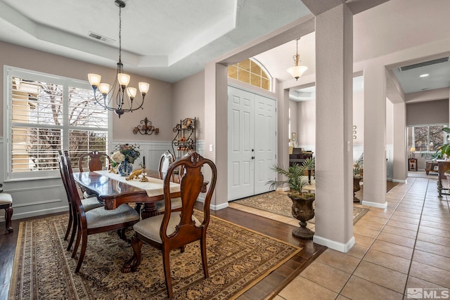 7972 Tres Arroyos Dr, Sparks, NV 89436 - dining room with a chandelier, a raised ceiling, a wainscoted wall, and light wood finished floors