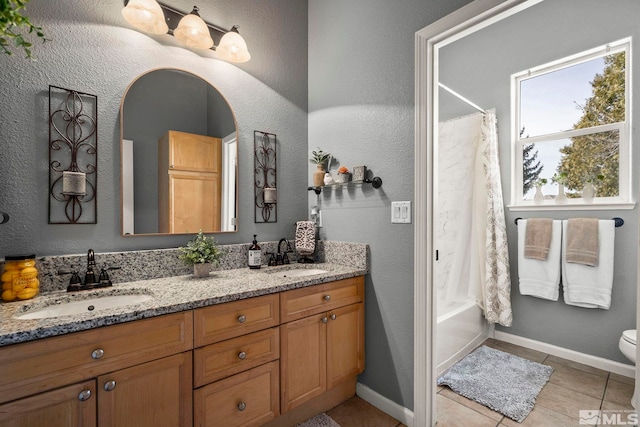 7972 Tres Arroyos Dr, Sparks, NV 89436 - bathroom featuring tile patterned floors, double vanity, shower / bath combination with curtain, toilet, and baseboards