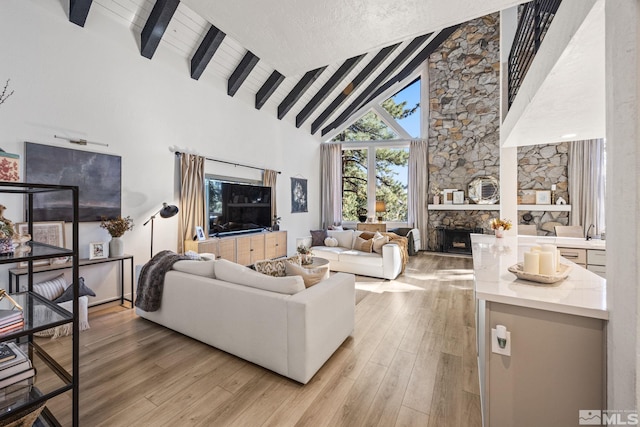 3055 US Highway 395, Washoe Valley, NV 89704 - living room with beamed ceiling, high vaulted ceiling, light wood finished floors, and a fireplace