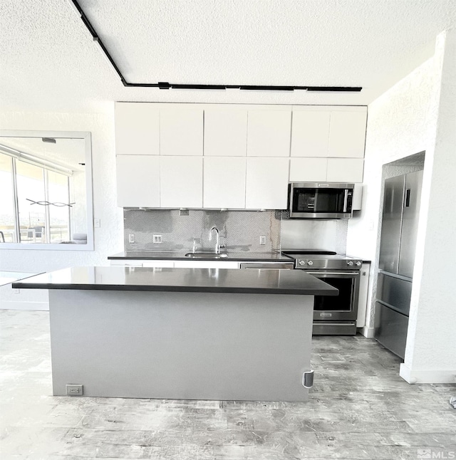 100 N Arlington Ave Unit 22-H, Reno, NV 89501 - kitchen featuring appliances with stainless steel finishes, white cabinetry, a textured ceiling, and modern cabinets