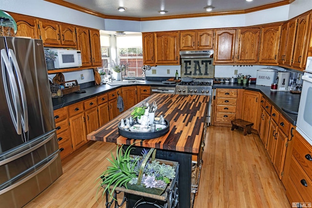 4635 Country River Dr, Fallon, NV 89406 - kitchen featuring stainless steel appliances, brown cabinets, dark countertops, light wood finished floors, and crown molding