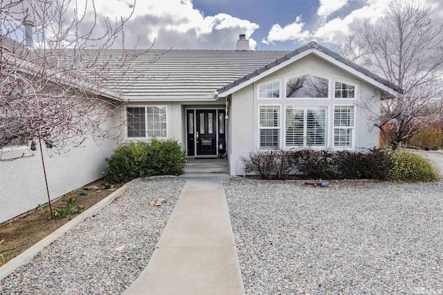 4635 Country River Dr, Fallon, NV 89406 - property entrance featuring a chimney, a tile roof, and stucco siding