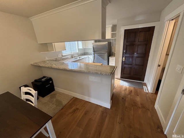 453 Mcfaul Unit 13, Zephyr Cove, NV 89448 - kitchen featuring freestanding refrigerator, a peninsula, a sink, dark wood finished floors, and white cabinetry