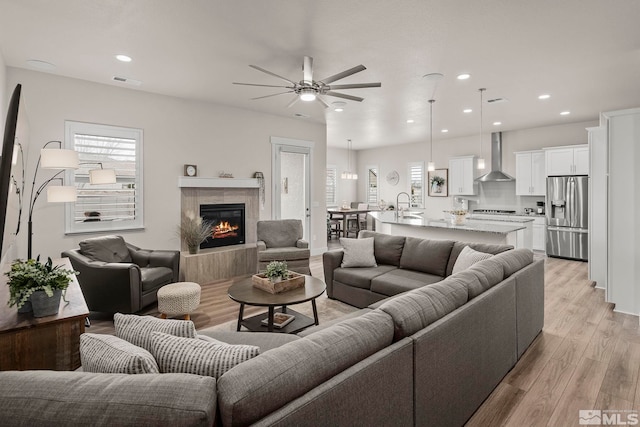 1046 Savona Ct, Dayton, NV 89403 - living area with light wood-type flooring, a ceiling fan, a fireplace, and recessed lighting