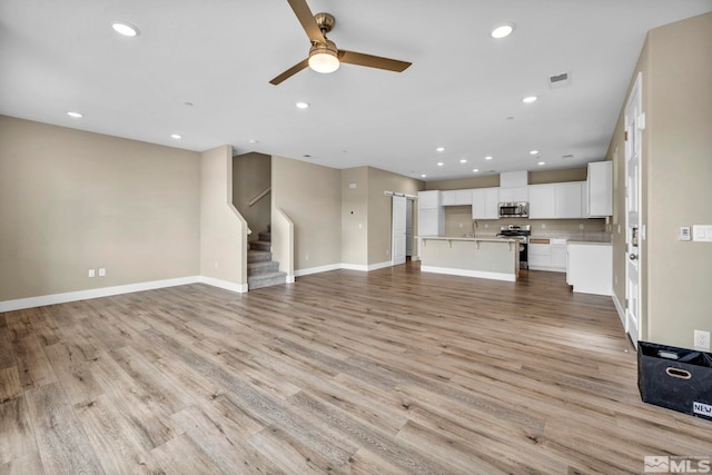 3660 Flare Ln Unit 2-2, Carson City, NV 89705 - unfurnished living room featuring ceiling fan, stairs, recessed lighting, light wood-style floors, and baseboards