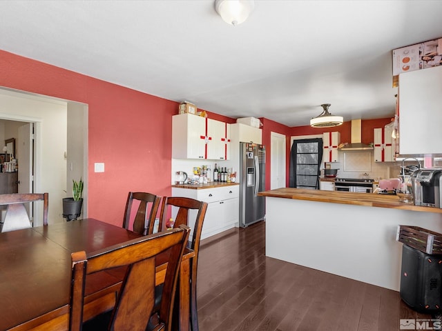 1879 Kings Canyon Rd, Carson City, NV 89703 - kitchen with wall chimney exhaust hood, appliances with stainless steel finishes, butcher block countertops, dark wood-style floors, and white cabinetry