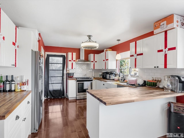 1879 Kings Canyon Rd, Carson City, NV 89703 - kitchen featuring butcher block countertops, appliances with stainless steel finishes, wall chimney range hood, and a peninsula