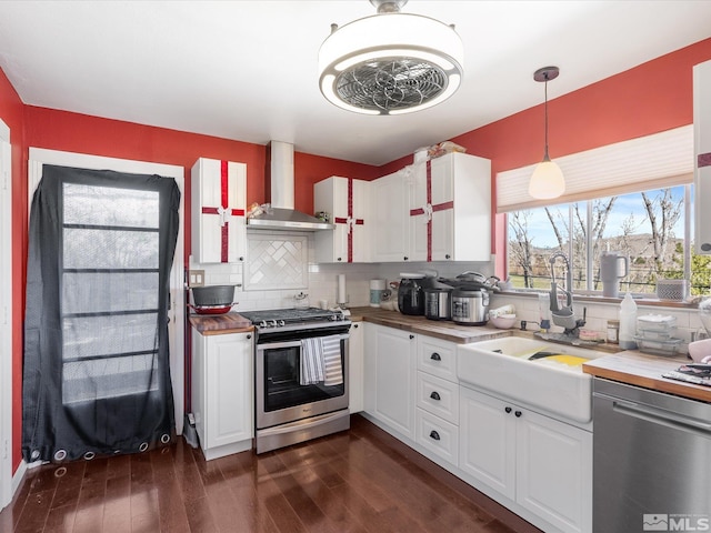 1879 Kings Canyon Rd, Carson City, NV 89703 - kitchen featuring stainless steel appliances, wall chimney range hood, a sink, decorative backsplash, and dark wood-style floors