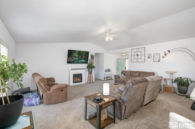 756 Megan Way, Fallon, NV 89406 - living area with carpet floors, a warm lit fireplace, a ceiling fan, vaulted ceiling, and baseboards