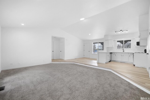 604 Venturacci Ln, Fallon, NV 89406 - unfurnished living room with vaulted ceiling, light carpet, baseboards, and recessed lighting