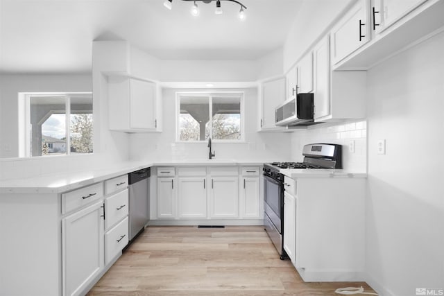 604 Venturacci Ln, Fallon, NV 89406 - kitchen with appliances with stainless steel finishes, white cabinetry, backsplash, and light wood-style floors