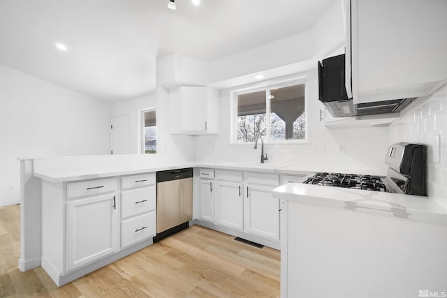 604 Venturacci Ln, Fallon, NV 89406 - kitchen featuring stainless steel dishwasher, range with gas cooktop, a sink, a peninsula, and light wood finished floors