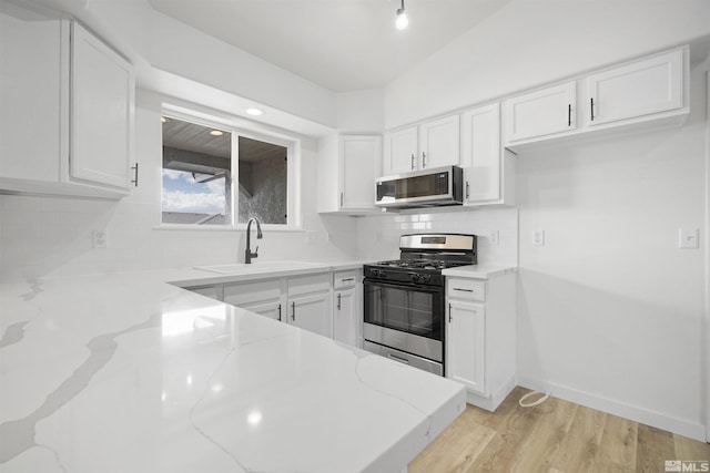 604 Venturacci Ln, Fallon, NV 89406 - kitchen featuring stainless steel microwave, black gas range oven, a sink, light stone counters, and white cabinetry
