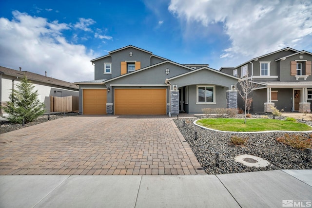 2181 Wyaconda Dr, Sparks, NV 89436 - view of front of home featuring stucco siding, decorative driveway, stone siding, fence, and an attached garage