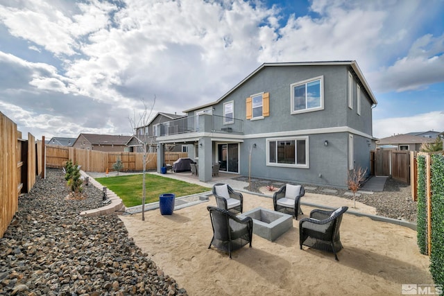 2181 Wyaconda Dr, Sparks, NV 89436 - back of property with an outdoor living space with a fire pit, a balcony, a fenced backyard, a patio area, and stucco siding