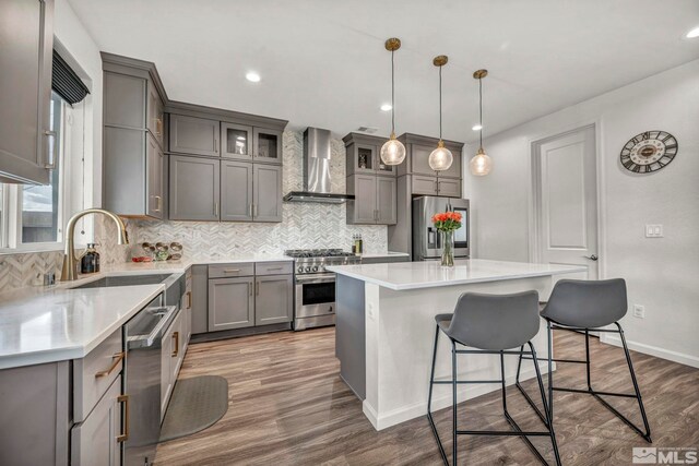 2181 Wyaconda Dr, Sparks, NV 89436 - kitchen with wall chimney range hood, appliances with stainless steel finishes, gray cabinetry, a sink, and recessed lighting